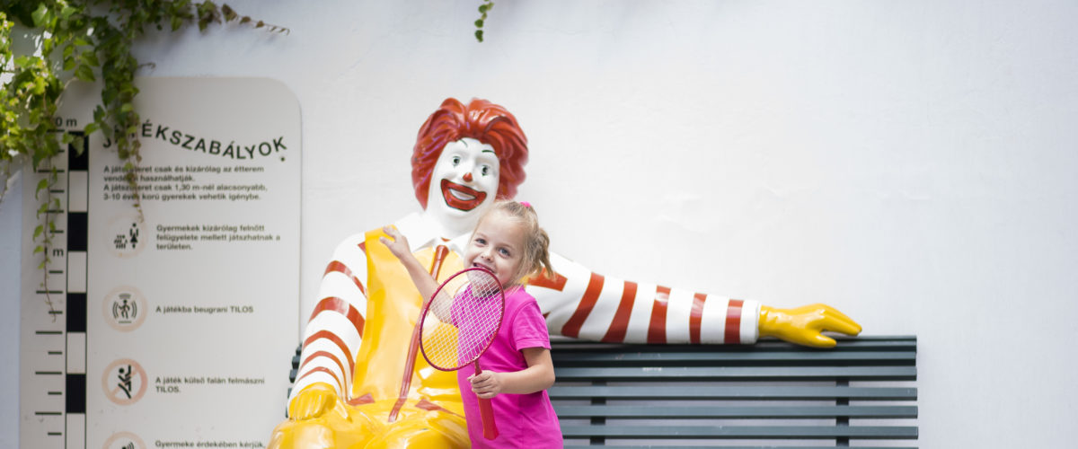 Kislány egy teniszütővel a kezében a McDonalds bohóccal